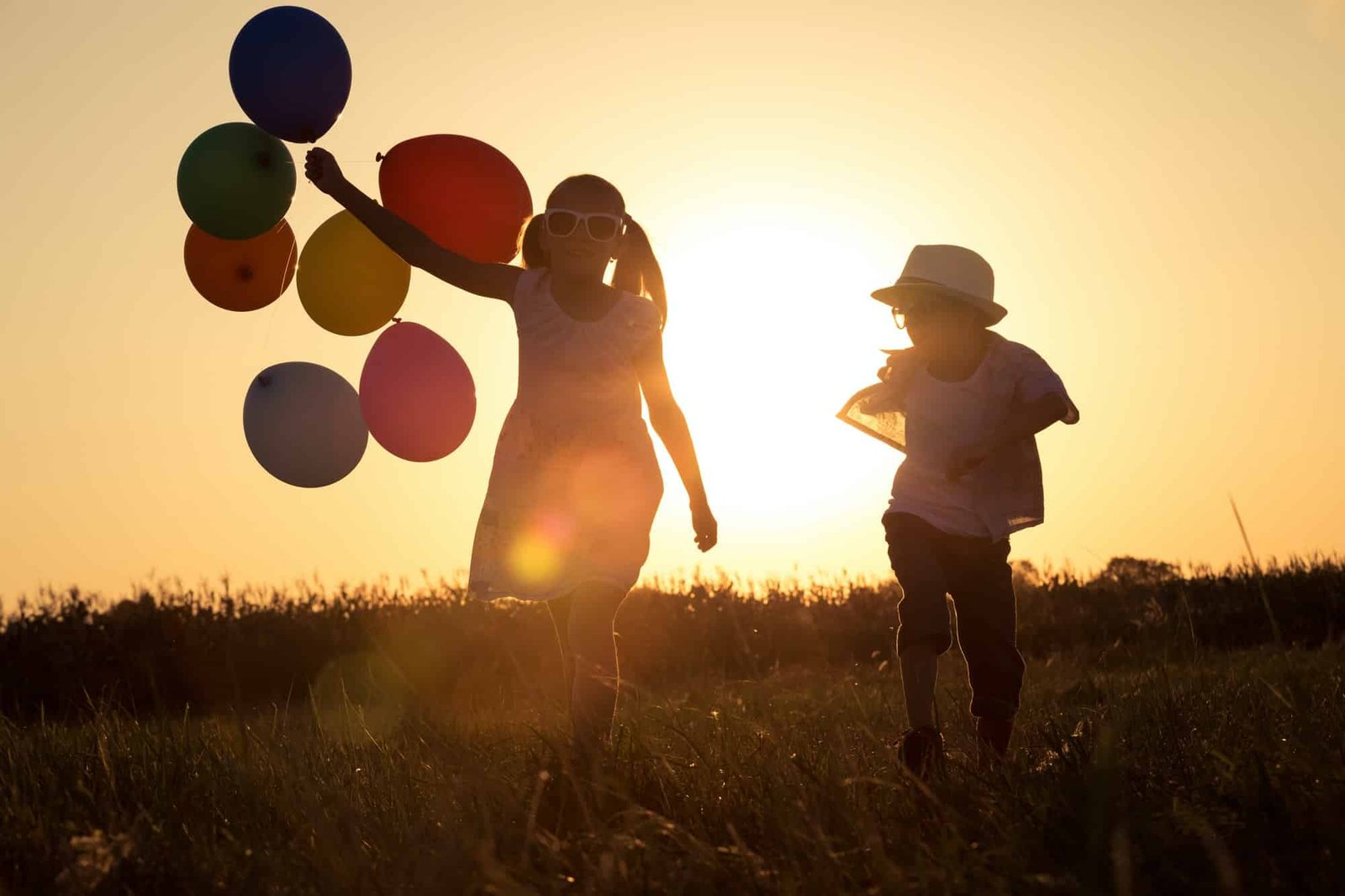 silhouette-of-two-happy-children-which-playing-on-the-field-at-t.jpg